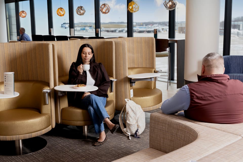 Travelers relaxing in the seating area of the Escape Lounge at Hartford Bradley Airport (BDL)