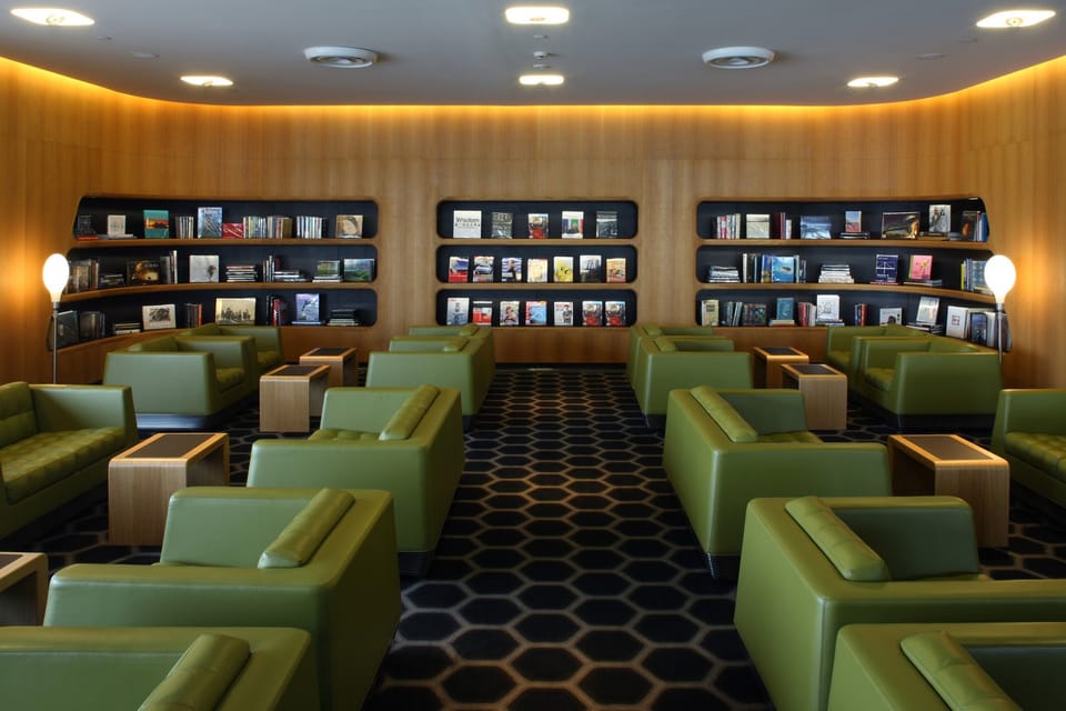 Library room with green leather armchairs and timber bookshelves in the Qantas Chairman's Lounge, Sydney Airport